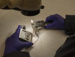 An examiner analyzes a piece of possible evidence in the laboratory. An examiner analyzes a piece of possible evidence in the laboratory.